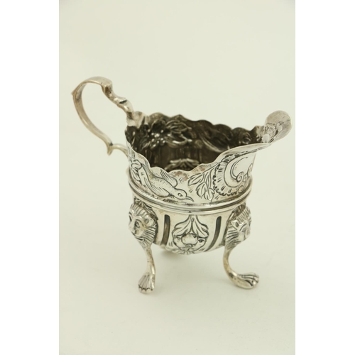 36 - A small Irish silver helmet shaped Cream Jug, by West and Son, Dublin, 1898, chased with birds, flow... 