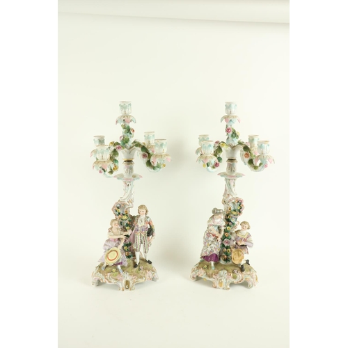 376 - A pair of Sitzendorf porcelain flower encrusted four branch five-light Candelabra, each with an asym... 