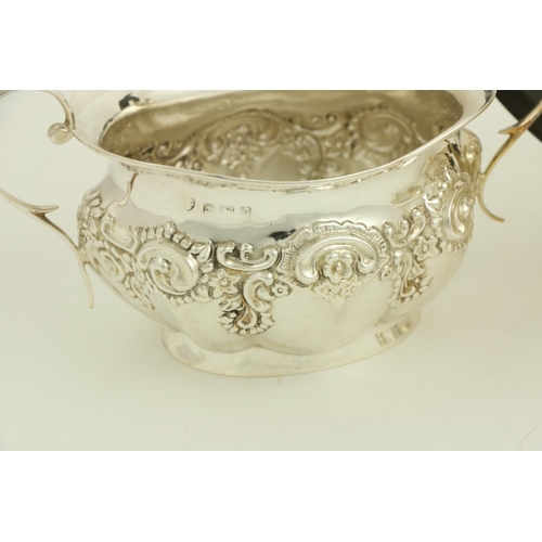 73 - A three piece silver Tea Service, Birmingham 1907, comprising an embossed oval teapot with hinged co... 