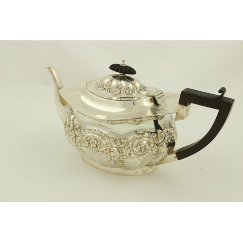 73 - A three piece silver Tea Service, Birmingham 1907, comprising an embossed oval teapot with hinged co... 