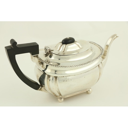 76 - A silver rectangular ogee shaped Teapot, Birmingham 1929, with bead edge and raised on four ball fee... 