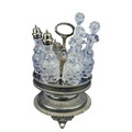 A silver plated rotating Cruet Stand, with six cutglass bottles, some with silver plated mounts. (1)... 