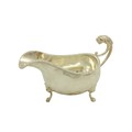A silver Sauceboat, in the George III style, London 1937, with lion mask handle and a gadroon edge, ... 