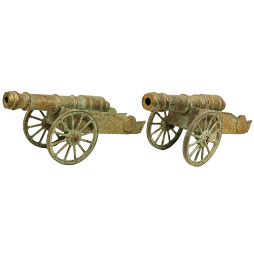 609 - A pair of attractive brass Cannon Carriages, O.R.M., embossed design, each on spoked wheels, approx.... 
