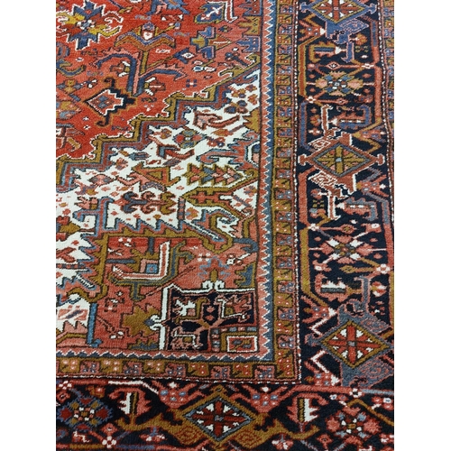 685 - A Persian Heriz Carpet, the iron red field with a centre medallion and all over pattern with ivory s... 