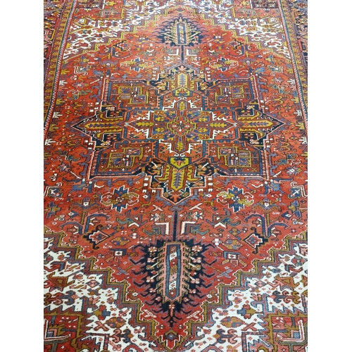 685 - A Persian Heriz Carpet, the iron red field with a centre medallion and all over pattern with ivory s... 