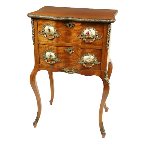 802 - A serpentine shaped French walnut and brass mounted Petite Commode, with brass mounts and porcelain ... 