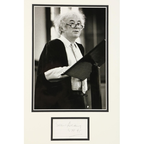 721 - [Heaney (Seamus)] An original black and white Press Photograph of Seamus Heaney standing at a p... 