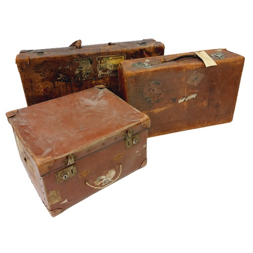 14 - Two similar antique leather Suitcases, (labels of travel locations and hotels) together with a leath... 
