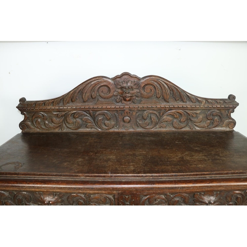 20 - A 19th Century Cromwellian style carved oak Buffet, the shaped back with central carved grotesque ma... 