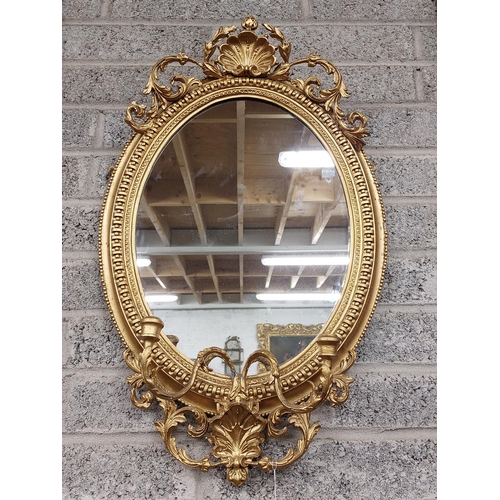 35 - A 19th Century oval gilt Girandole Mirror, with shell crest issuing scrolling leaves on a bead mould... 