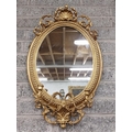 A 19th Century oval gilt Girandole Mirror, with shell crest issuing scrolling leaves on a bead mould... 