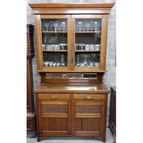 60 - An Edwardian walnut Chiffonier or Cabinet, the moulded cornice above two glazed doors above a vacant... 