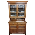 An Edwardian walnut Chiffonier or Cabinet, the moulded cornice above two glazed doors above a vacant... 