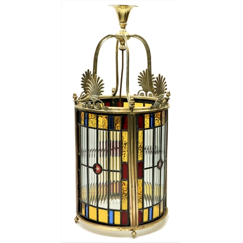 An attractive Regency style brass Hall Lantern, of cylindrical form with beaded and coloured glass panels crested with four brass anthemions, 30'' (77cms). (1)