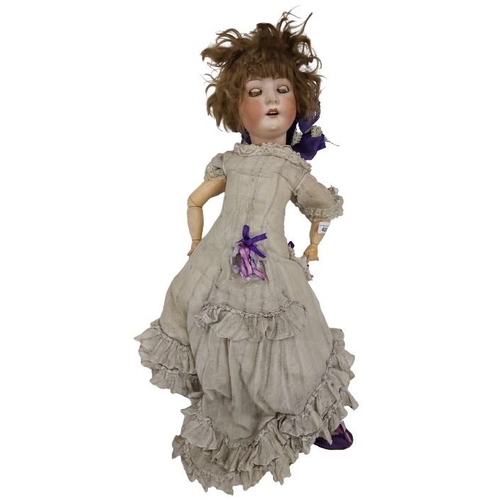 420 - A late 19th Century porcelain Child's German Doll, marked, wearing linen dress and purple shoes, as ... 