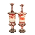 An extremely fine pair of Bohemian ruby Urns and Covers, c. 1870, each etched with a woodland scene,... 