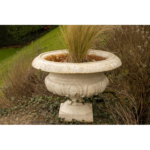 550 - A pair of cast iron Garden Urns, each with folded rim on half reeded body and stem base, 43cms (17