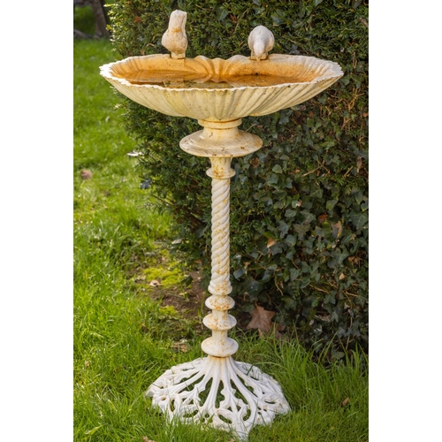 551 - An attractive cast iron Bird Bath, with shell shaped bowl surmounted with two birds on a spiral reed... 