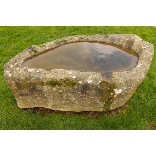 556 - An early highly important naturally formed granite Horse Trough, with carved out centre, asymmetrica... 