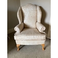 A pair of modern wing back Armchairs, each covered in alphabetical printed beige fabric on front cab... 