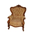 A pair of Victorian style walnut button back Armchairs, each with cartouche crest above a loose cush... 