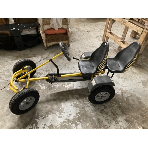 569 - A Child's double seat pedal action Go Cart, by BERG, painted yellow. (1)