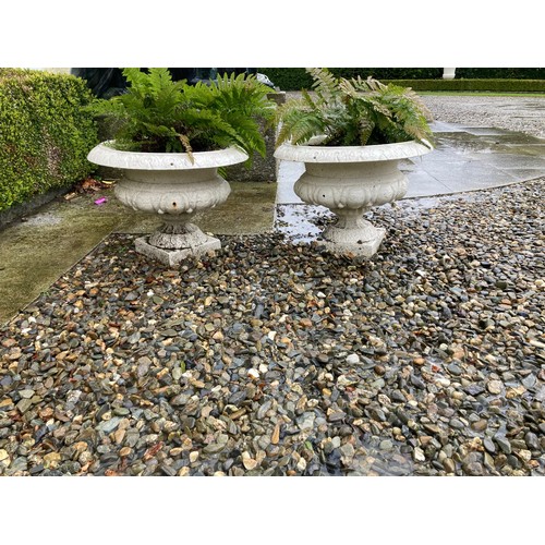 561 - A pair of heavy cast iron Garden Urns, each with folded rim on half reeded body on square base, 45cm... 