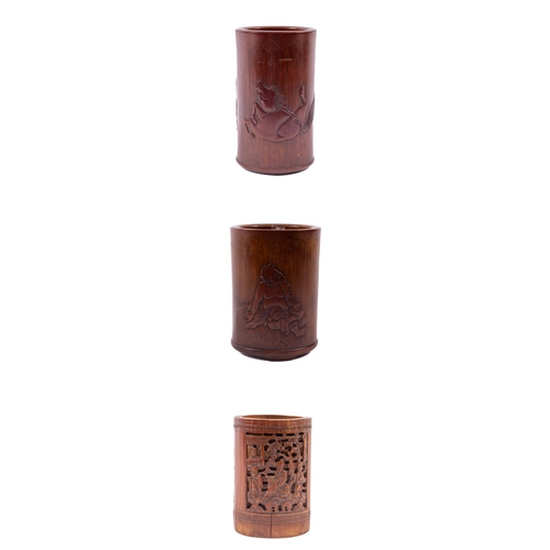 A very good early Chinese carved bamboo Brush Pot, of cylindrical form depicting a large man seated on a rug, 15cms (6"); a Chinese bamboo Brush Pot, carved in deep relief with four figures by a pavilion and two lines of calligraphy and a single oval panel with a phoenix, 13cms (5 1/4"); and a very fine early bamboo Brush Pot, depicting a man with rolling horse in low relief and three lines of calligraphy, 15cms (6"). (3)