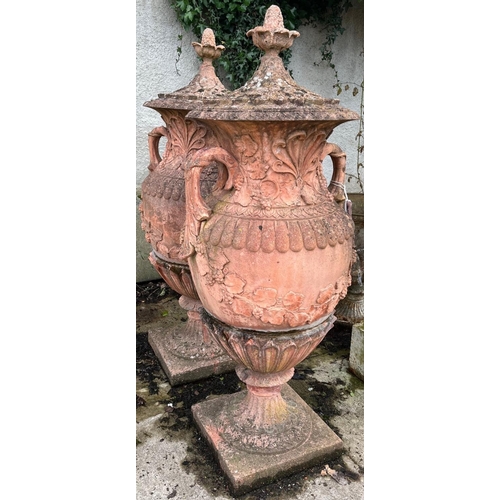 1373 - An impressive pair of terracotta coloured composition stone Garden Urns, each relief moulded with sc... 