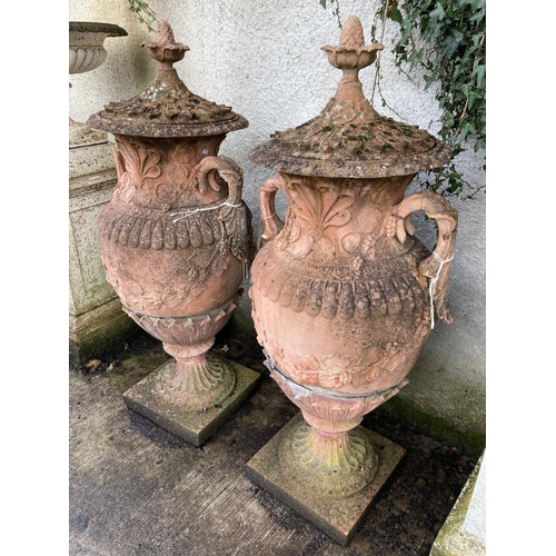 1373 - An impressive pair of terracotta coloured composition stone Garden Urns, each relief moulded with sc... 