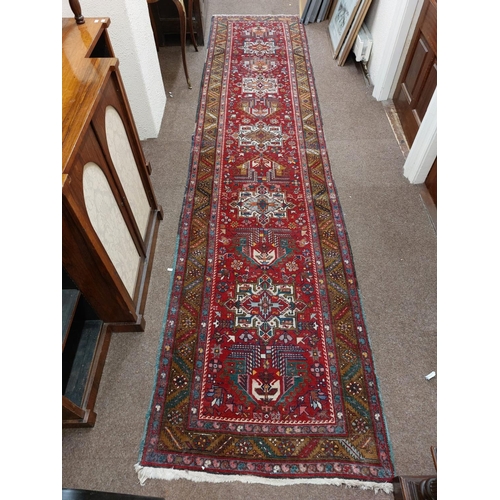 716 - A fine quality Middle Eastern woollen Runner, the central red ground with five medallions, inside a ... 