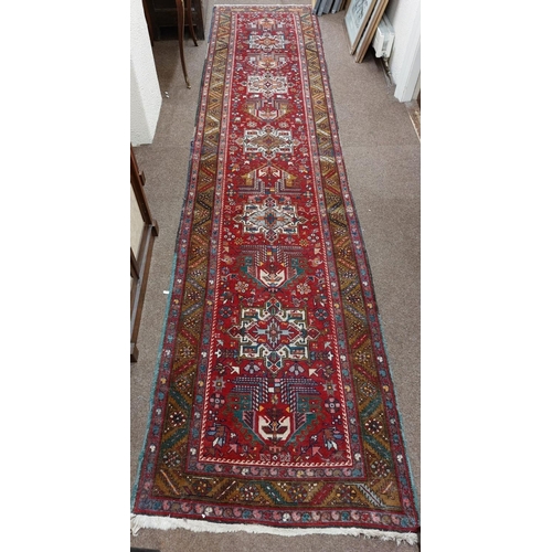 716 - A fine quality Middle Eastern woollen Runner, the central red ground with five medallions, inside a ... 