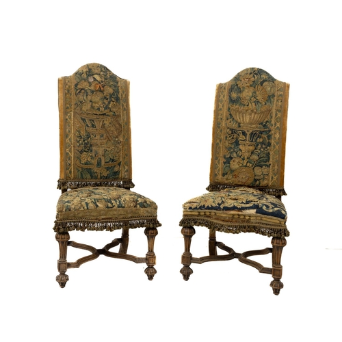 810 - A pair of Louis XIV style walnut Side Chairs, on reeded shaped legs united by X stretchers, covered ... 