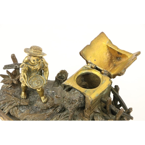 960 - An attractive 19th Century gilt bronze Inkstand, modelled with a young boy feeding a dog by a kennel... 