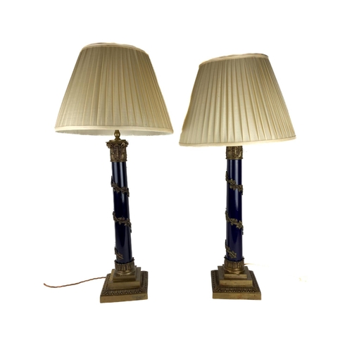 1068 - An attractive pair of brass mounted and ebonised Table Lamps, each with a brass Doric capital a... 