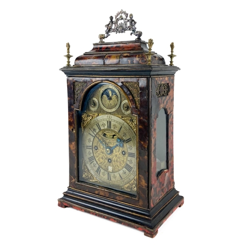 An important English three-train tortoiseshell Bracket Clock, of c.1740, its break-arch brass dial signed ‘Abraham Ferron’ with a rolling moon with engraved faces surrounded by an age-of-moon dial in its arch, along with ‘Strike/Silent’ and ‘Chime/Silent’ dials, its dial with mock-pendulum and date apertures and highly engraved with foliate scrolls centred by a Tudor rose; its triple-fusee movement with highly engraved backplate with floral and foliate designs and signed ‘Abraham Ferron, St. Annes Churchyard’, quarter chiming on eight bells and striking on a further bell; its tortoiseshell case with extensive gilt-brass banding and flambeau-brass finials and an elaborate brass handle, and pierced-brass frets backed by silk to front and sides.