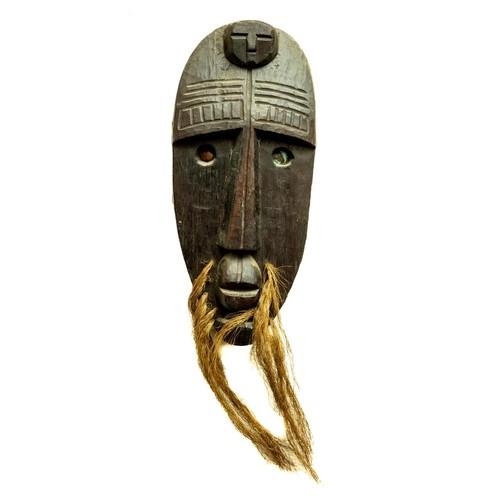 246 - A good carved wooden African Tribal Mask, with hairy whiskers and oval face with copper inset eyes, ... 