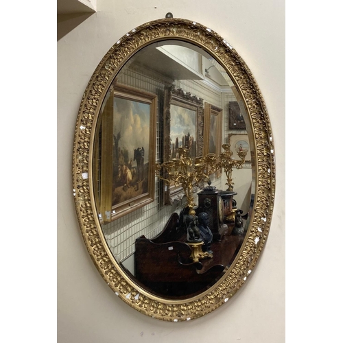 601 - A large late 19th Century oval gilt Mirror, with leaf decoration and bevelled mirror, approx. 102cms... 