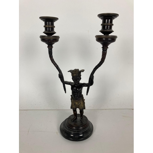 748 - A bronze Candelabrum, modelled as an Aboriginal Young Man holding two spiral reeded candle arms, in ... 