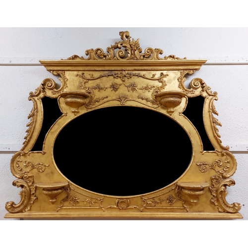 38 - An ornate gilt and gesso Overmantel, with leaf scroll and floral crest above a large oval bevelled p... 