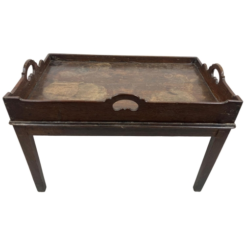 105 - A late 19th Century oak Butlers Tray, with three saw cut handles, now on a fixed stand on square tap... 