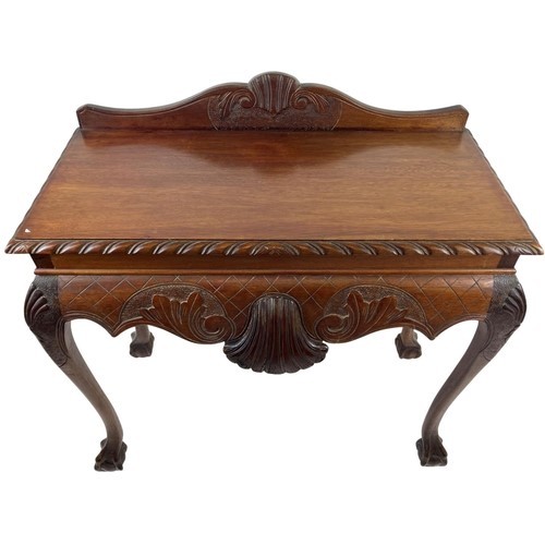 123 - A carved mahogany Side Table, in the Irish style, with shell and scroll back and gadroon edge above ... 