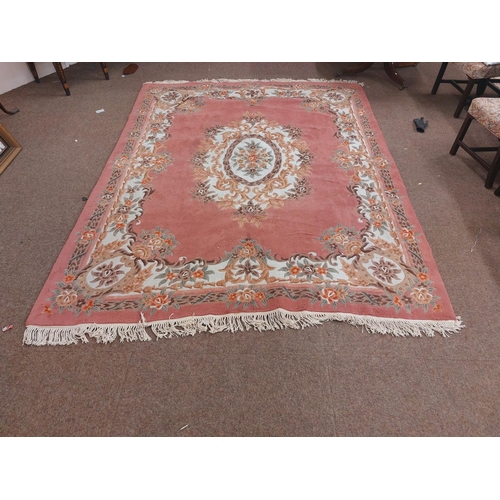 424 - A large pink ground Chinese woollen Carpet, with large central floral bouquet and conforming border,... 