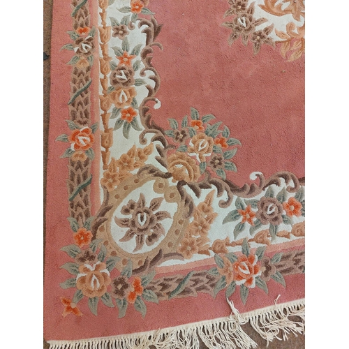 424 - A large pink ground Chinese woollen Carpet, with large central floral bouquet and conforming border,... 