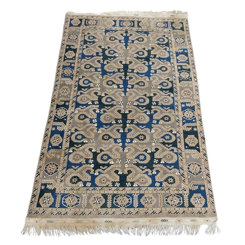 426 - A semi-antique Middle Eastern blue and green ground geometric and diamond design Carpet, the large c... 