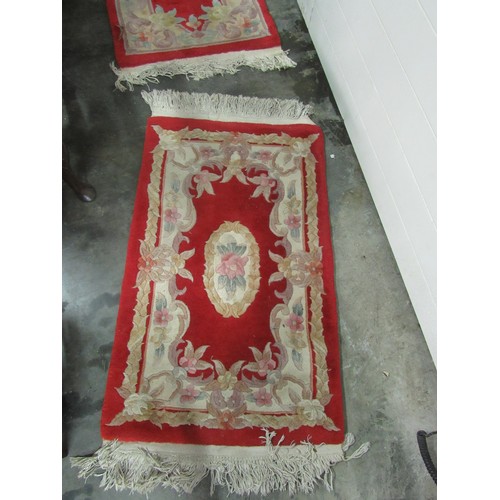 428 - A suite of 3 red ground Chinese woollen Rugs, with central conforming medallion, each approx. 116cms... 