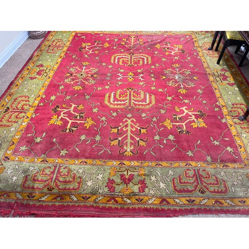 1185 - An attractive Irish woolen Carpet, probably Donegal, the centre claret ground panel with floral and ... 