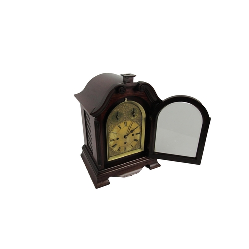 1054 - An attractive mahogany cased Mantle Clock, with swan neck pediment over an arched glazed door housin... 