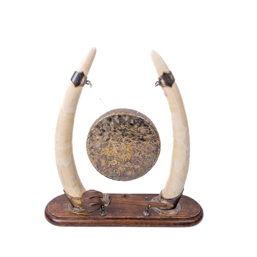 1058 - A late Victorian Dinner Gong, formed between two horns with plated mounts and brass suspended circul... 